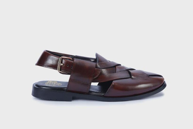 Handmade brown leather Peshawari sandals with woven closed-toe design and adjustable buckle for men's traditional and formal wear.