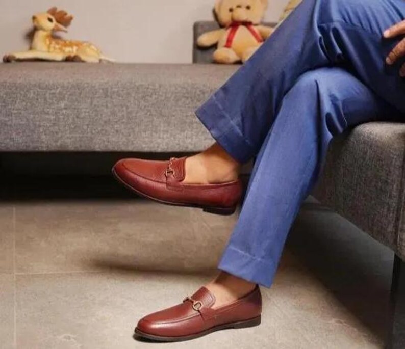 Handmade brown pebbled leather horsebit loafers for men featuring silver hardware, genuine leather lining, slip-on construction, and a luxury formal dress shoe design.