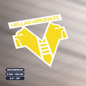 Peut inclure: Un autocollant jaune et blanc Hellas Verona FC. L'autocollant présente le logo de l'équipe, une forme de V stylisée avec deux têtes de lion et le texte "HELLAS VERONA FC". L'autocollant est étanche et mesure 6 cm-140 cm.
