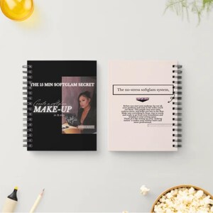 May include: Two spiral-bound notebooks. The black notebook has text that reads "THE 15 MIN SOFTGLAM SECRET" and "Create a softglam MAKE-UP". The other notebook is light pink with the text "The no-stress softglam system."
