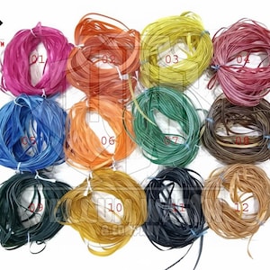 Peut inclure: Douze bobines de cordon en cuir plat et fin de couleurs vives. Chaque bobine présente une couleur différente, notamment rose, orange, jaune et bleu, disposées en cercle. L'image contient le texte "VELLUM WASTM & JEWELRY".