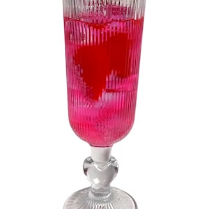 Potion d&#39;amour - faux cocktail rose, tranches de fraise, glace, rose dans un verre, accessoire sans alcool