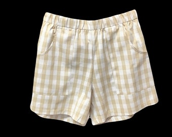 May include: Beige checkered shorts with a wide elastic waistband and two front pockets.