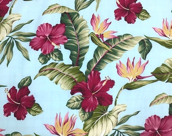 May include: A blue fabric with a tropical print featuring large red hibiscus flowers, green banana leaves, and yellow bird of paradise flowers.