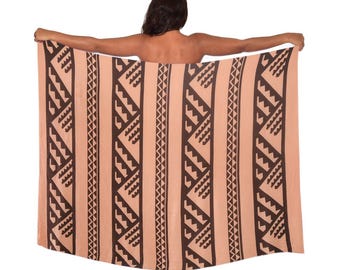 May include: A peach-colored rectangular beach towel with a repeating geometric pattern in dark brown. The pattern consists of vertical stripes with alternating zigzag and triangular shapes. The towel is held up against a white background.