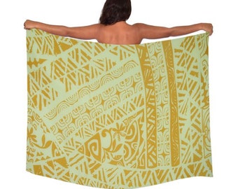 May include: A green and gold patterned sarong with a geometric design. The sarong is being worn by a person.