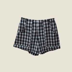 K&ouml;nnte beinhalten: Schwarz-wei&szlig;e karierte Shorts mit Kordelzug und zwei Taschen.