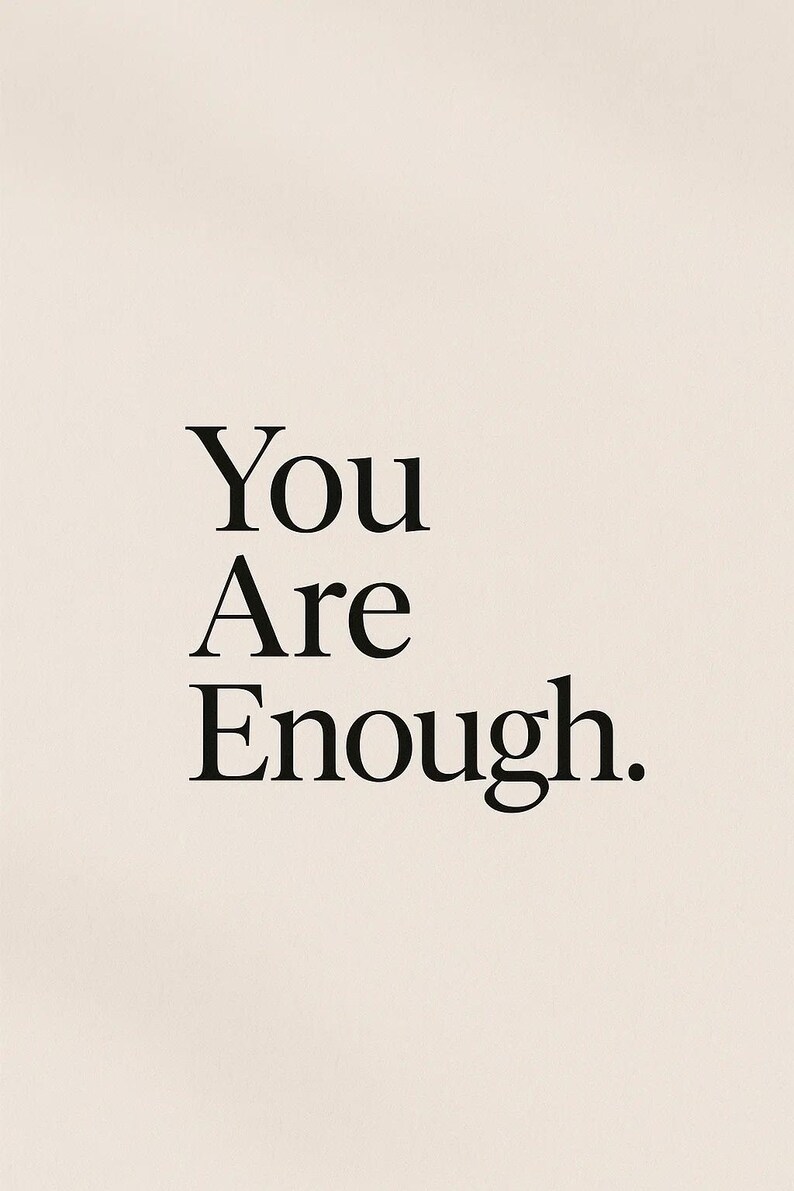 May include: A minimalist print on a cream background features the words "You Are Enough" in a bold, black serif font. The simple design is centered, creating a clean and modern aesthetic.