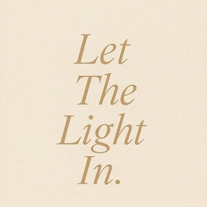May include: A beige background with the words "Let The Light In" in a gold serif font. The text is centered and vertically aligned, creating a simple and elegant design.