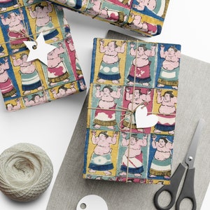 May include: Gift-wrapped boxes with a colorful sumo wrestler pattern. The boxes are tied with twine and adorned with white paper tags. A ball of twine, scissors, and additional tags are also visible.