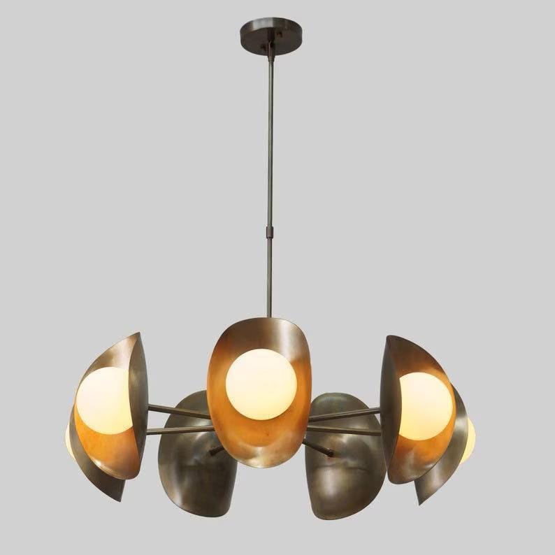May include: A modern, brass chandelier with six globe-shaped light bulbs. The chandelier has a circular design with the bulbs positioned in a staggered pattern.
