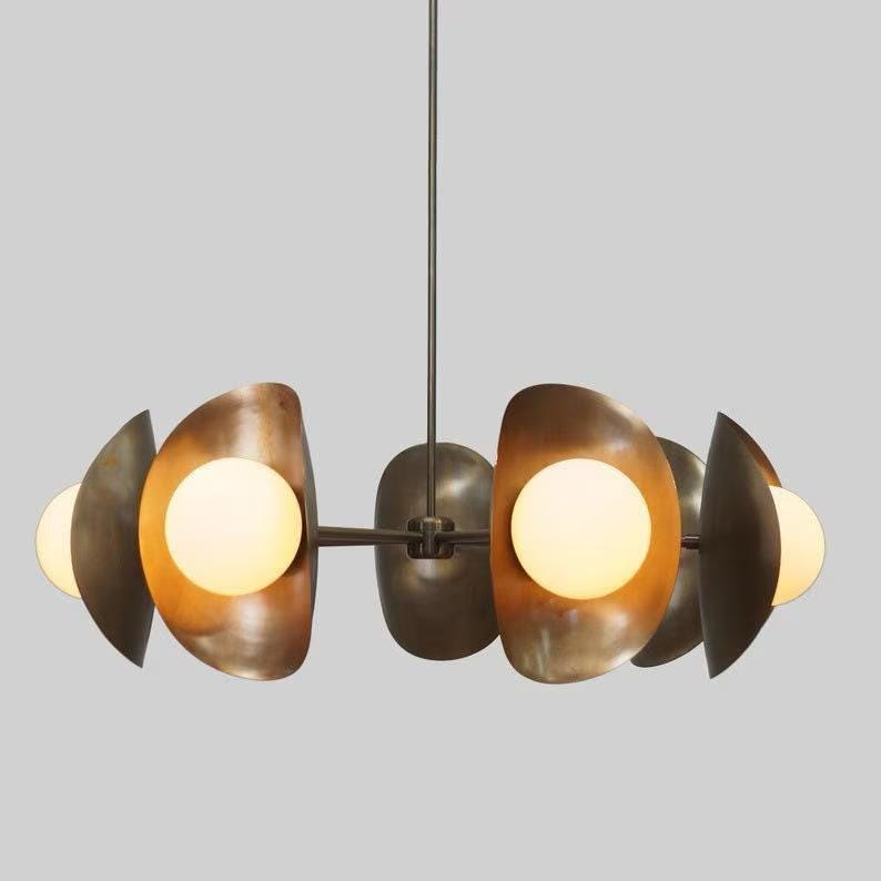 May include: A modern, six-light chandelier with a brushed brass finish and white globe shades. The chandelier has a unique, organic design with curved arms and a central hub.