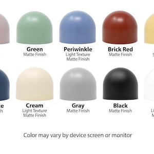 May include: Ten color swatches of paint in a dome shape. The colors are mauve, green, periwinkle, brick red, yellow, coal blue, cream, gray, black, and white. The swatches are labeled with the color name and finish type, such as satin or matte.