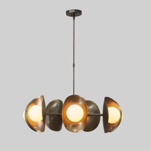 May include: A modern, brass chandelier with six round, frosted glass shades. The chandelier has a circular design with the shades arranged in a staggered pattern.