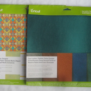 May include: Two Cricut packaging samples. The left sample is for Washi Sheets, Designer, Feuilles de Papier Japonais Washi, Elégant, Hojas de Papel Washi, Exclusivas. The right sample is for Faux Leather, Pebbled, Patina Sampler, Echantillonneur Patine Granulé Similicuir, Muestra Patina Simil Cuero Granulado.