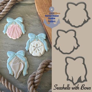 May include: Cookies decorated as seashells with light blue bows. The cookies are in the shape of a scallop shell, a sand dollar, and a conch shell. Cookie cutters in the shape of seashells are also shown. The text "Seashells with Bows" is at the bottom.