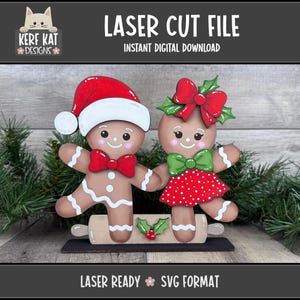 Può includere: Decorazione natalizia tagliata al laser con due omini di pan di zenzero. Uno indossa un cappello da Babbo Natale e un papillon, l'altra un vestito a pois rossi e un fiocco verde. Il testo "LASER CUT FILE" e "INSTANT DIGITAL DOWNLOAD" è visibile.