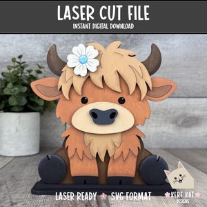 Puede incluir: Figura de vaca de las Tierras Altas cortada con láser de madera con una flor en la cabeza. La vaca es marrón, beige y negra, con una flor que tiene un centro azul. El texto "LASER CUT FILE" y "INSTANT DIGITAL DOWNLOAD" están en la parte superior. El texto "LASER READY SVG FORMAT" está en la parte inferior.