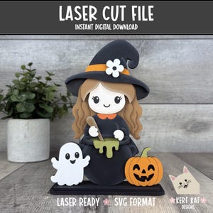 May include: A laser cut file digital download featuring a cartoon witch with long brown hair wearing a black hat with an orange band and white flower. The witch stirs a green potion in a black cauldron, accompanied by a white ghost and orange pumpkin.