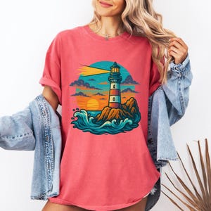 Lighthouse on Rocky Coast Comfort Colors 1717 T-Shirt – Vintage Ocean Waves Graphic Tee with Sunset for Coastal Nautical Style
