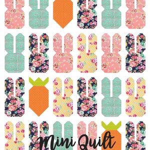 May include: A mini quilt featuring a repeating pattern of bunny rabbits and carrots. The bunnies are made from various floral fabrics in pink, blue, yellow, and black. The carrots are orange with green tops. The quilt is labeled "Mini Quilt".