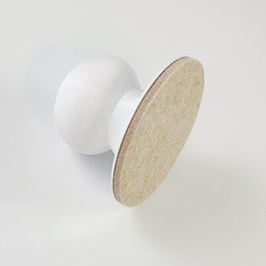 May include: White plastic furniture glide with a beige felt pad.