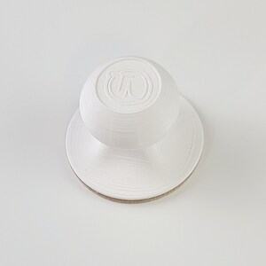 May include: White plastic knob with a circular base and a raised "T" logo on the top.