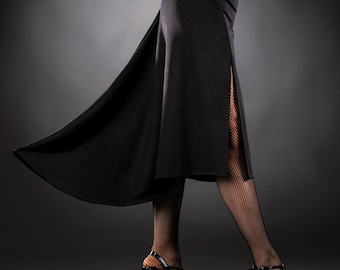May include: A black, high-waisted skirt with a side slit, paired with black fishnet stockings and black high-heeled shoes with red soles. The skirt flows gracefully, suggesting movement. The outfit is suitable for dance or evening wear.