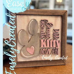 May include: Wooden sign with a paw print, heart, and the words "Beans, Biscuits, Purr, Kitty, Love Cat." The sign is in a brown frame with the text "Easely Created" on the sign and the background.