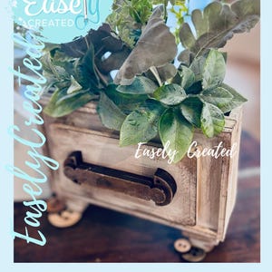May include: A rustic wooden drawer filled with various green plants and foliage. The drawer has a distressed, aged appearance with a dark metal handle. The text "Instant Digital Download Easely Created" is visible in the image.