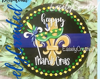 May include: A black round wooden sign with the text "Happy Mardi Gras" and a gold fleur-de-lis with a green and yellow mask. The sign is decorated with green and yellow beads.