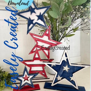 May include: Four wooden stars in red, white, and blue with a distressed paint finish. The stars are stacked on top of each other and are on a white surface. The text "EaselyCreated" is visible on the bottom star.
