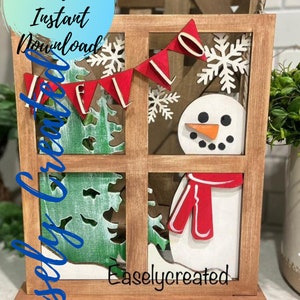May include: A wooden window frame with a snowman, a red scarf, a green tree, and a red banner that says "Hello" in white letters. The window frame is on a wooden base.
