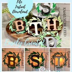 May include: A set of four wooden letters spelling "BIRTH" with green leaf wreaths around each letter. The letters are on a tiered wooden stand. The letters are also available as night lights with a warm glow.