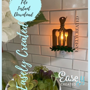 Puede incluir: Una luz nocturna de madera con forma de tabla de cortar con un tenedor, un cuchillo y una cuchara recortados. La luz está enchufada a una toma de corriente y está encendida. La luz nocturna está en una pared de azulejos blancos. El texto "Easley Created" es visible en la imagen.