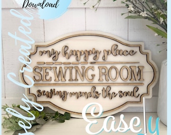 May include: A wooden sign with the text "my happy place SEWING ROOM sewing mends the soul" in a decorative font. The sign is white with brown lettering and has a distressed look. The sign is on a white background with green plants.