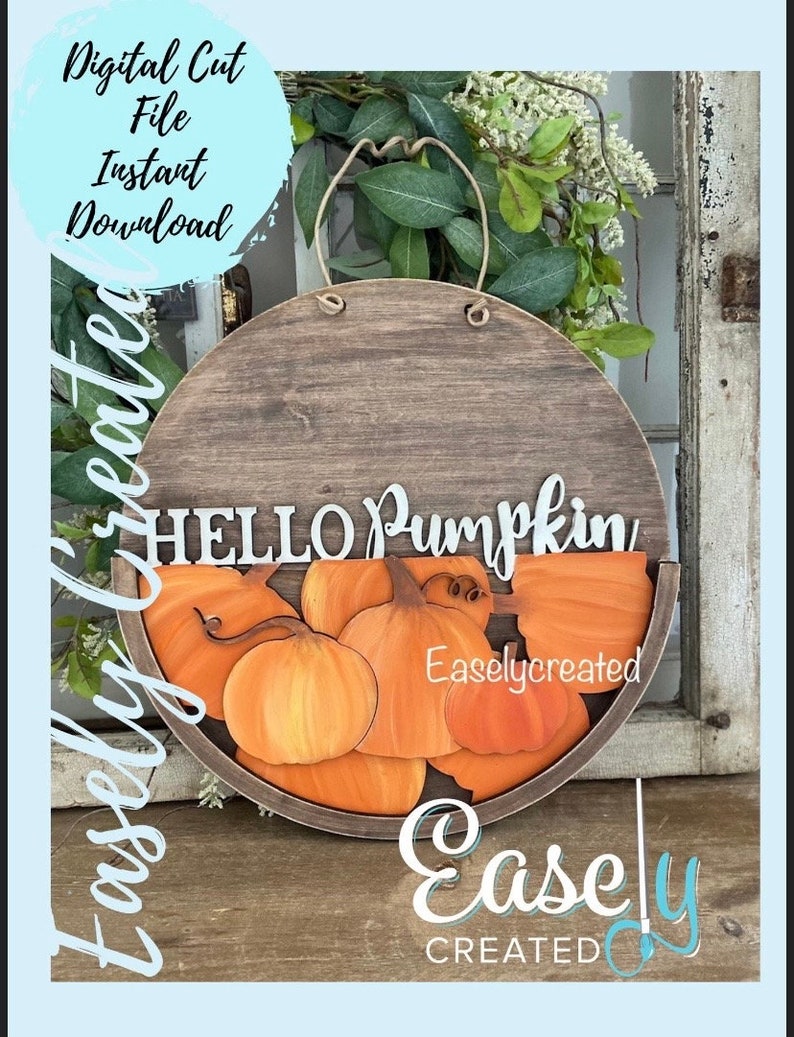 Pu&ograve; includere: Un cartello rotondo in legno con un manico in corda, che presenta il testo "HELLO PUMPKIN" e un semicerchio di zucche arancioni. Il cartello &egrave; decorato con un motivo a venature di legno marrone e il testo "Easlycreated" &egrave; visibile nell'angolo in basso a destra.