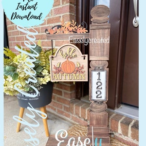 May include: A wooden fall-themed welcome sign with a pumpkin, leaves, and the words "hello autumn". The sign is attached to a wooden post with a house number plaque that reads "122".
