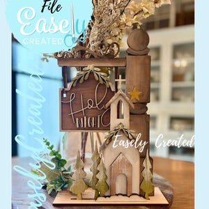 May include: Wooden Christmas decoration featuring a church, trees, and a sign that reads "Holy Night." The design includes a star and decorative foliage. The words "Digital Cut File" and "Easely Created" are also visible.