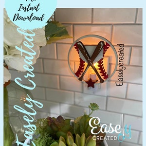 May include: A white wooden nightlight shaped like a baseball with red stitching and two crossed bats. The nightlight is lit and glowing. The text "Easley Created" is visible in the image.
