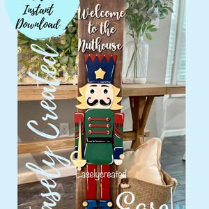May include: A wooden nutcracker sign with the text "Welcome to the Nuthouse." The sign features a colorful nutcracker soldier design with a green jacket, red pants, and a blue hat with a gold star. The sign is a digital cut file.