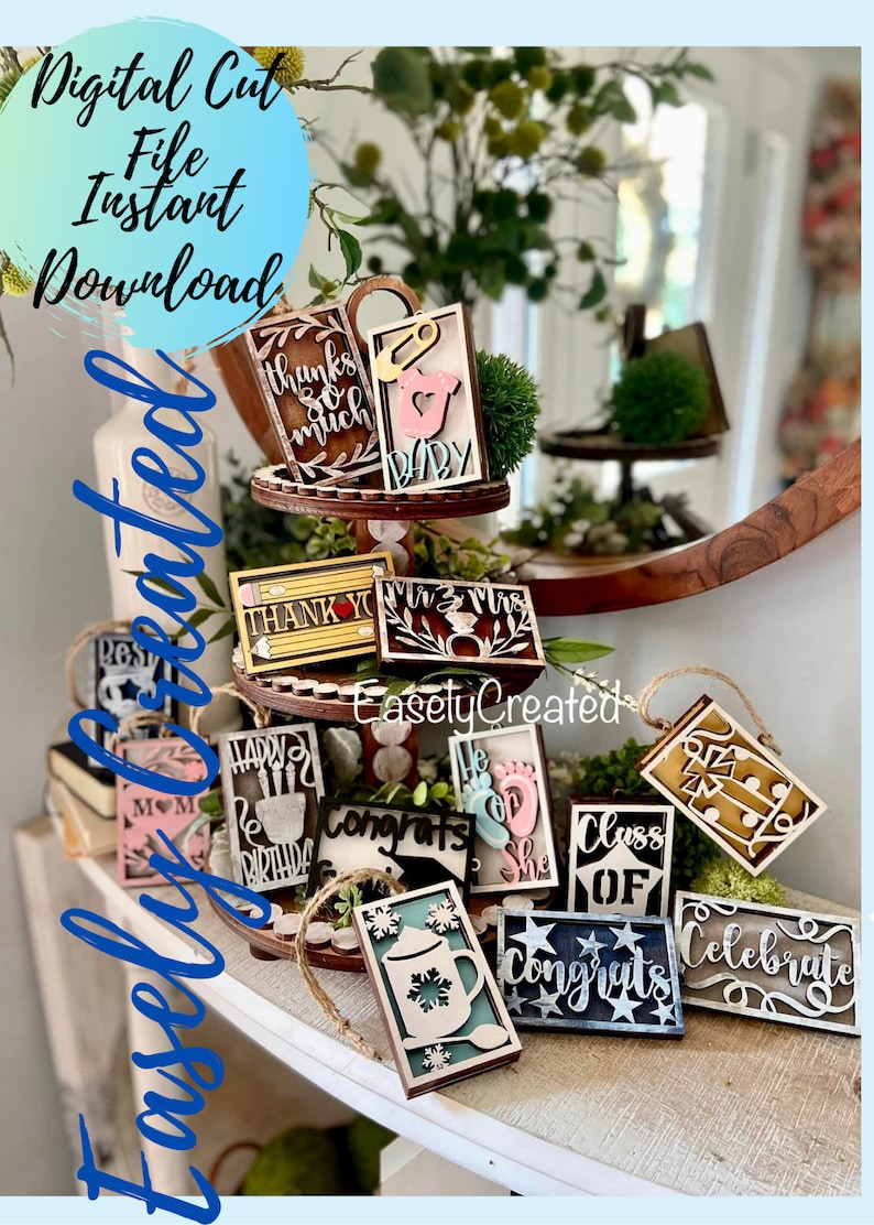 May include: A collection of wooden signs with various sayings and designs, including "Thanks so much", "Baby", "Thank You", "Mr. & Mrs.", "Happy Birthday", "Congrats", "He or She", "Class of", "Congrats", and "Celebrate". The signs are displayed on a tiered wooden stand and a shelf.