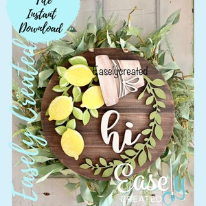 May include: A wooden round sign with a lemon theme. The sign features yellow lemons, green leaves, and the word "hi" in white. The sign is surrounded by greenery and has the text "Easely Created" on it.