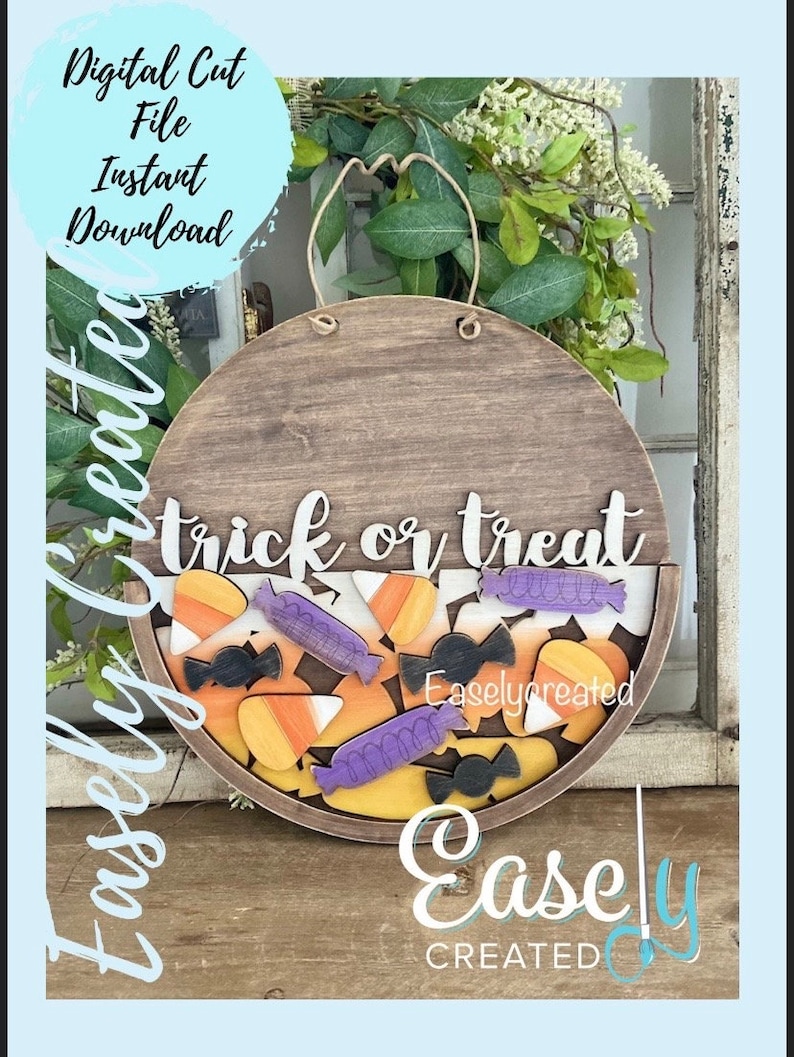 Pu&ograve; includere: Un cartello rotondo in legno con il testo "trick or treat" in lettere bianche. Il cartello &egrave; decorato con mais caramellato, barrette di cioccolato e lecca-lecca in arancione, giallo, viola e nero. Il cartello &egrave; appeso a una corda e ha uno sfondo marrone.
