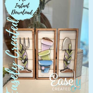 May include: Three wooden signs with a farmhouse style design. The signs feature a gardening theme with a trowel, a fork, and a stack of flower pots. The signs are painted in shades of green, blue, and pink.