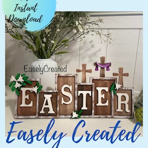 Könnte beinhalten: Holzbuchstaben, die das Wort "EASTER" buchstabieren, mit einer abgenutzten weißen Lackierung. Die Buchstaben sind in einer versetzten Anordnung angeordnet, mit einem kleinen Kreuz auf jeder Seite des "E" und "R". Die Buchstaben sind mit kleinen weißen Blumen und grünen Blättern verziert. Der Hintergrund ist hellblau.