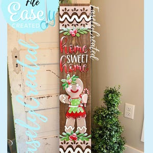 May include: Wooden sign with a gingerbread man and the words "Home Sweet Home." The sign has a brown background with white and red accents. The text "Digital Cut File Easily Created" is also visible.