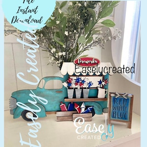 May include: A wooden craft project featuring a blue pickup truck with a red and white fireworks stand. The truck has a sign that says "Fireworks" and the stand has a sign that says "Red White Blue".