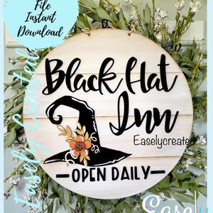 May include: A round wooden sign with the text "Black Hat Inn" in black script font. A black witch's hat with an orange flower is centered on the sign. The sign also says "Open Daily" and "Easlycreated".