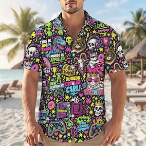 May include: A short-sleeve button-down shirt featuring a vibrant, chaotic all-over print on a black background. The design includes neon-colored graphics of skulls, cats, dinosaurs, game controllers, donuts, and text like Dungeon Crawler Carl.